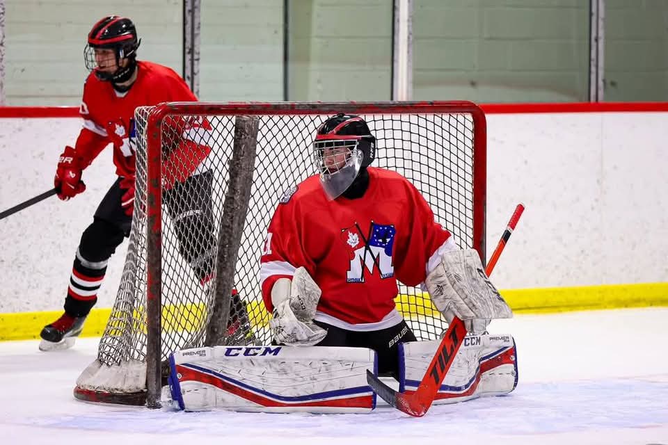 Goalie in red jersey ready in net with Tilt goalie stick