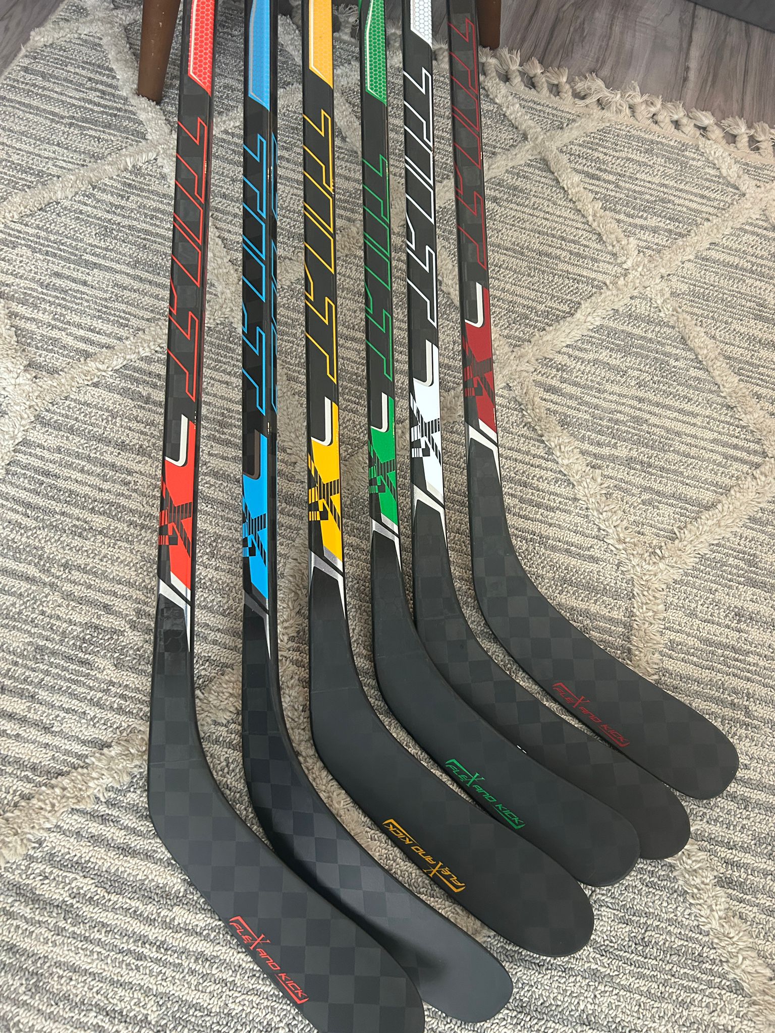 Colorful Tilt hockey sticks lined up showing multiple vibrant colorways